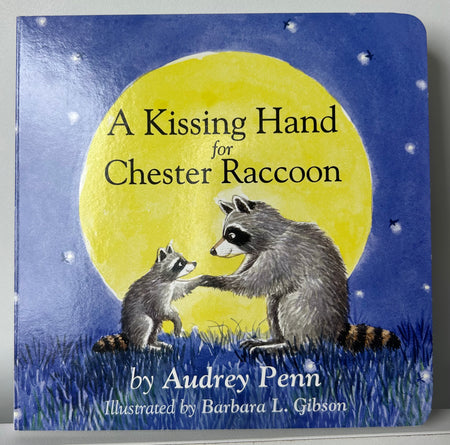 Book cover of A Kissing Hand for Chester Raccoon by Audrey Penn, showing an adult and baby raccoon touching paws beneath a bright yellow moon and starry night sky.