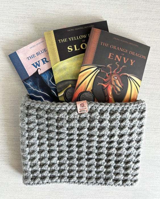 Seven Deadly Dragons virtue book set with prayer card, WonderGuide™, and ‘Pray to Slay’ bracelet on gray textured background.
