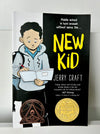 Cover of “New Kid” by Jerry Craft – a middle grade graphic novel featuring a cartoon boy with a sketchbook and backpack. Newbery Medal winner exploring identity, race, and belonging.