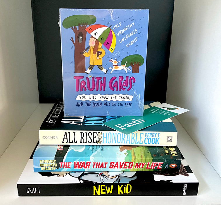 Stack of three middle-grade books—New Kid, The War That Saved My Life, and All Rise for the Honorable Perry T. Cook—topped with a boxed set of Truth Cards and a teal bookmark on a white shelf.