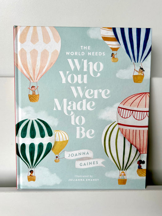 Cover of The World Needs Who You Were Made to Be by Joanna Gaines, featuring whimsical hot air balloons floating across a soft blue sky with fluffy clouds.