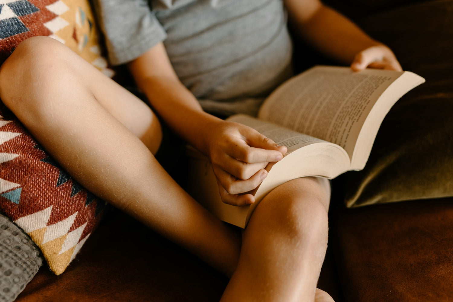 Child reading quietly, reflecting during a calm moment with a book.