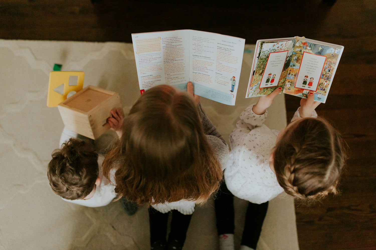Three children reading Catholic picture books together — story-centered virtue formation through Wonder & Wisdom Books.